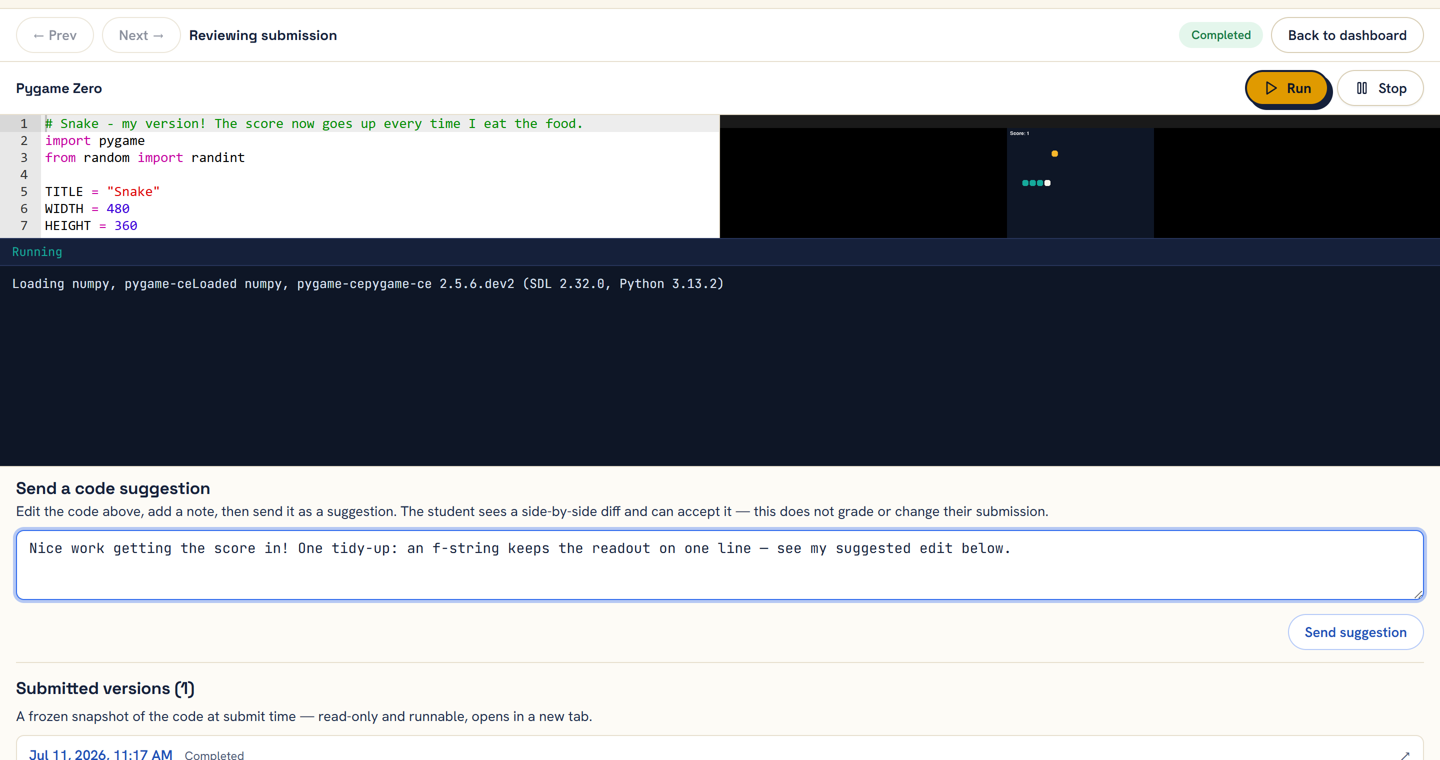 A teacher reviewing a student’s running Snake game and writing feedback on their code